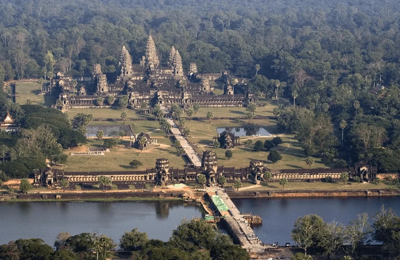 High angle aerial view of Angkor Wat temple complex and its main entrance causeway across the moat in Siem Reap.