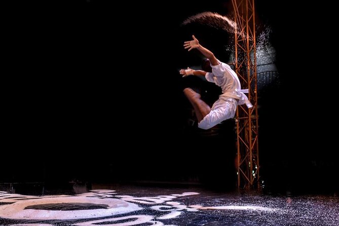 An acrobat mid-air performing a dramatic jump during a live Phare Circus theater show in Siem Reap.