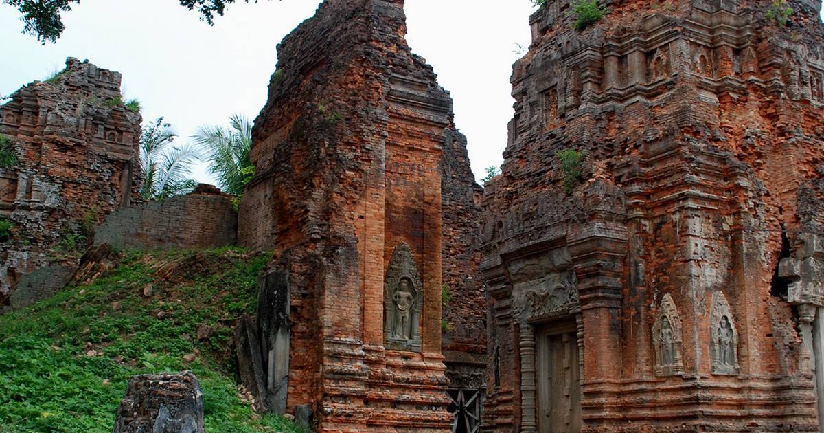 Ancient red brick ruins of Prasat Lolei temple with detailed devata stone carvings in Siem Reap Cambodia