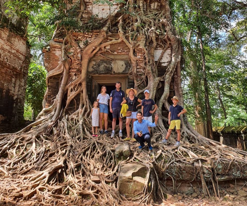 Ancient brick temple tower completely swallowed and encased by massive tree roots at Prasat Pram in Koh Ker Cambodia