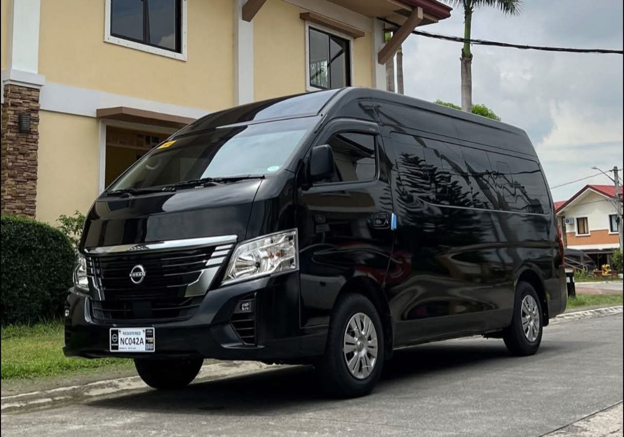 Sleek black Nissan Urvan passenger van parked on a residential road in Siem Reap Cambodia