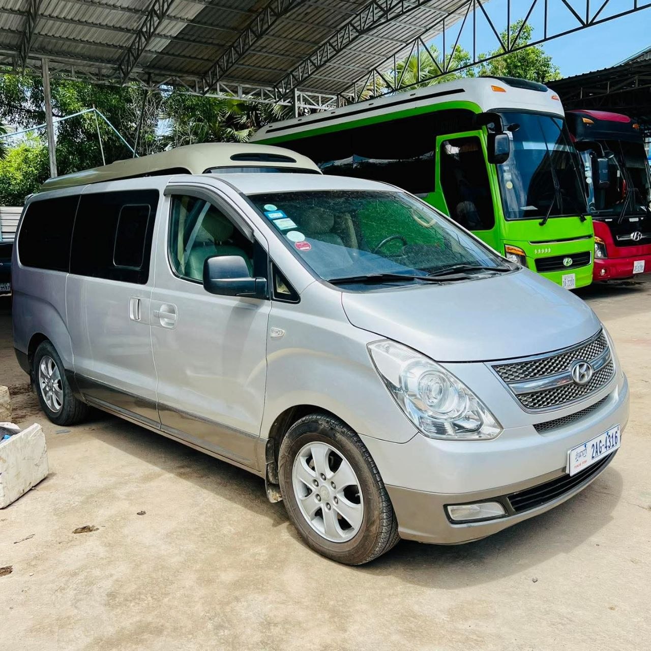 Silver Hyundai Starex passenger minivan parked in a transport lot in Siem Reap Cambodia