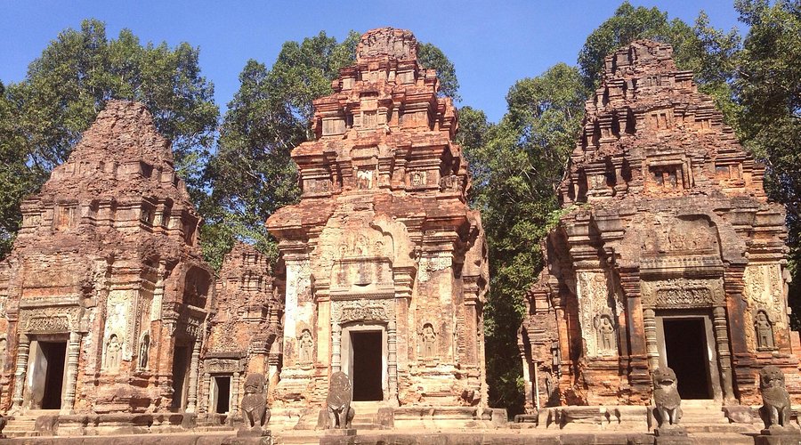 Three ancient red brick towers with detailed stone carvings at Preah Ko temple in Siem Reap Cambodia